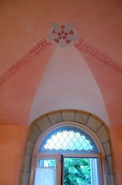 Bóveda estucada sobre ventana en arco con vidriera
