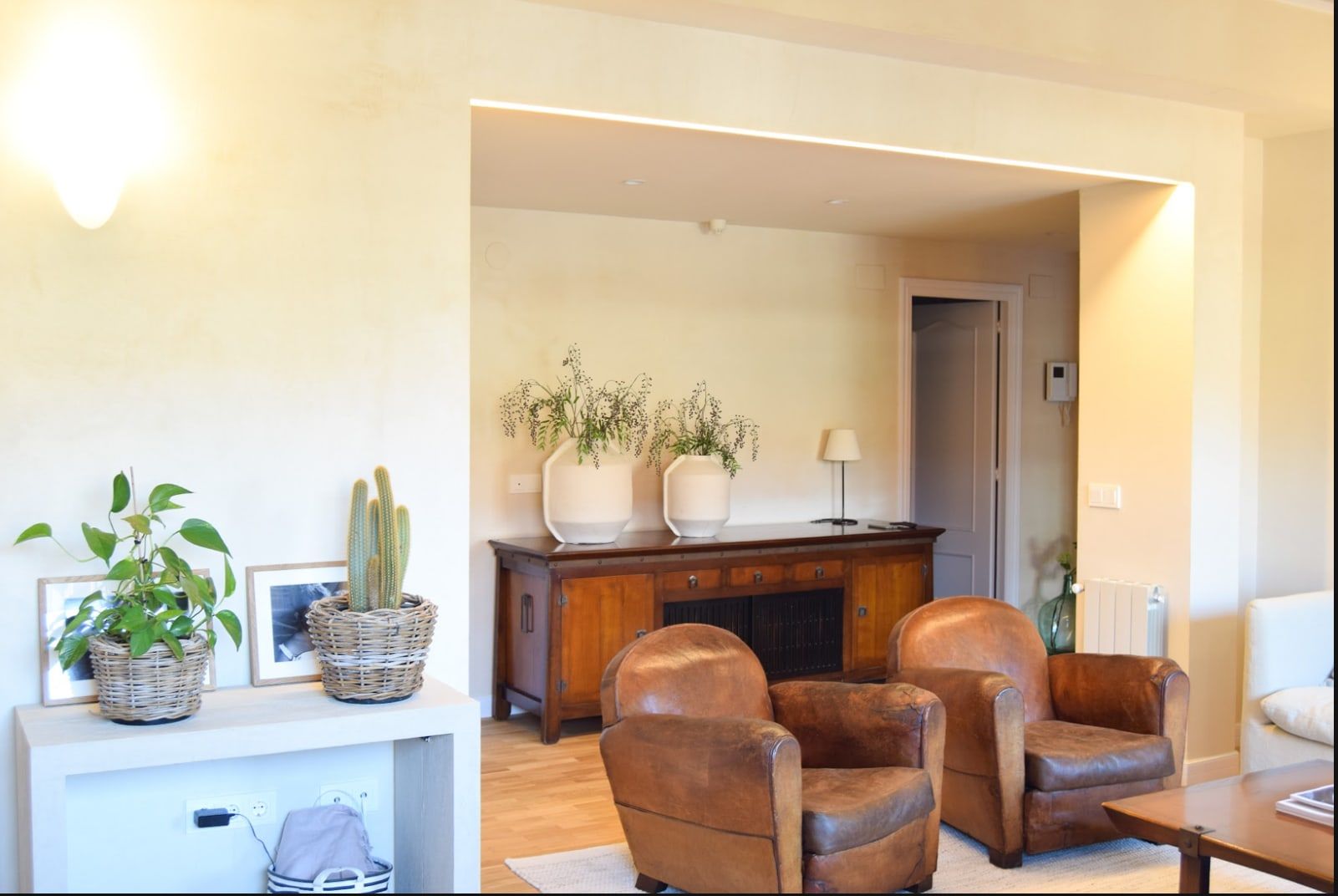 Salón con sillones de cuero marrón y aparador de madera