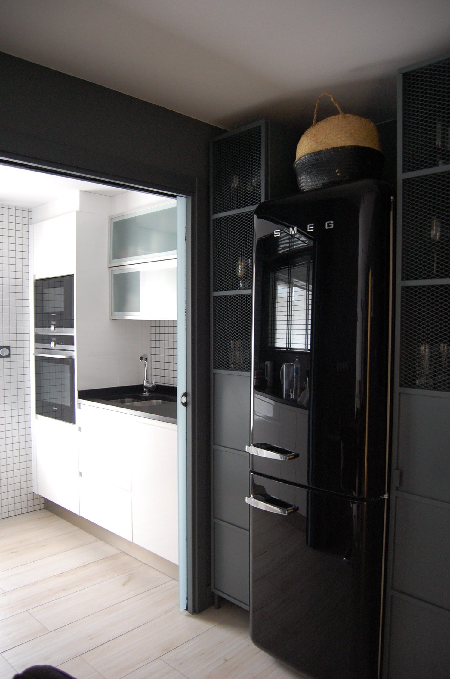 Cocina blanca con frigorífico negro retro y columnas en gris oscuro