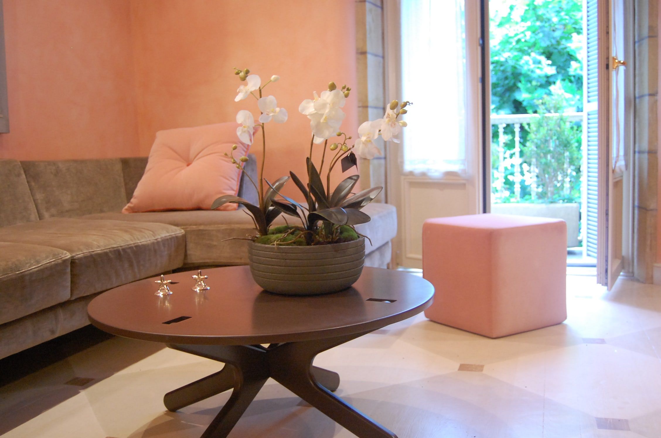 Mesa de centro con orquídeas junto a la salida al jardín
