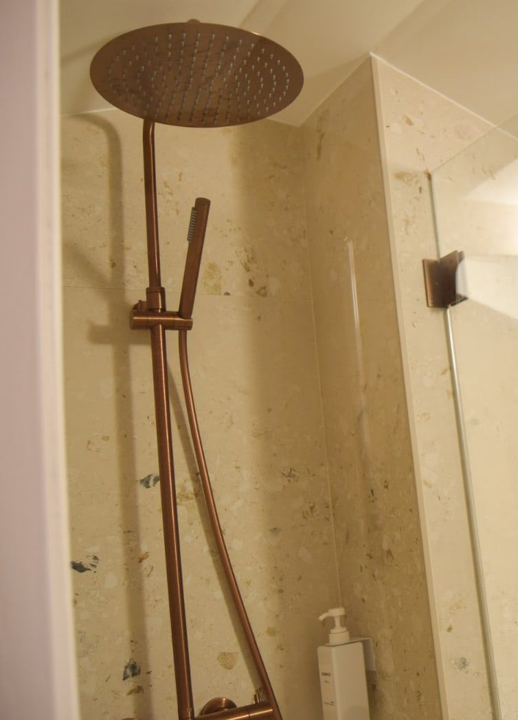 Ducha de piedra con rociador de techo en acabado bronce