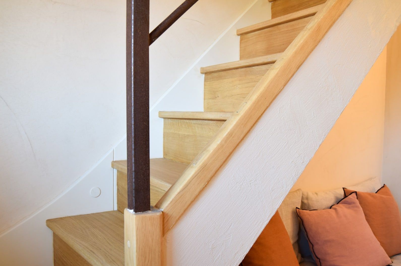 Escalera de madera con cojines en tonos tierra